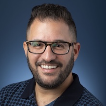 Adam Fingerhut headshot blue background